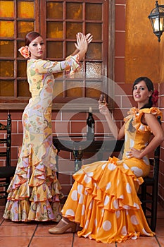 Women and man in traditional flamenco dresses dance during the Feria de Abril on April Spain