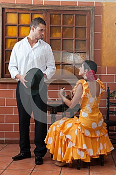 Women and man in traditional flamenco dresses dance during the Feria de Abril on April Spain