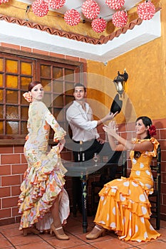 Women and man in traditional flamenco dresses dance during the Feria de Abril on April Spain