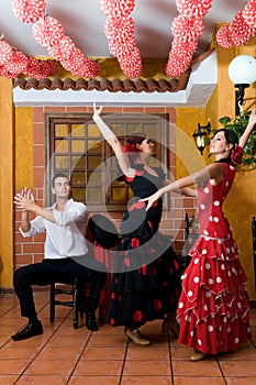Women and man in traditional flamenco dresses dance during the Feria de Abril on April Spain photo