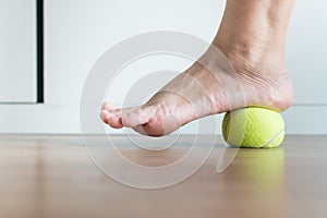 Women massage with tennis ball to her foot in bedroom,Feet soles massage for plantar fasciitis