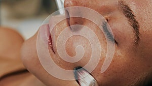 Women massage their faces with brushes.