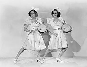 Women in matching outfits playing drums