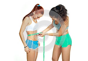 Women measuring waist with a tape