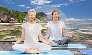 Women meditating in yoga lotus pose outdoors