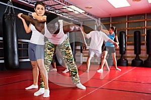 Women and men exercising during self-defence training