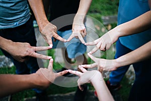 Women and men friends make star shape from fingers. Success, friendship