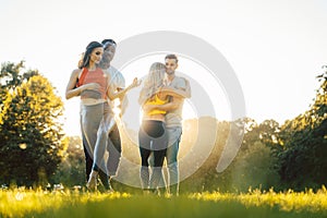 Women and men having fun dancing in the park