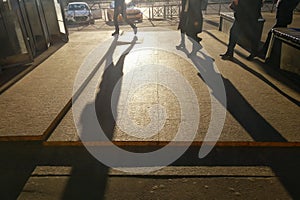 Women and men walking through the city streets. People rush to work. Passengers go to the subway