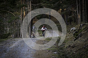 Women and mountain biking man riding on bikes in the mountains forest landscape