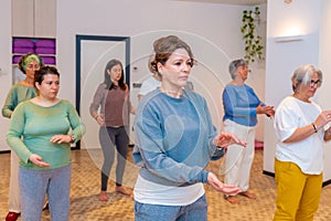 Women moving coordinated join hands in a qi gong class