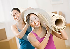 Women moving into new home and carrying rub