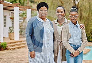 The women of our family. Cropped portrait of an adorable little girl standing outside with her mother and grandmother.