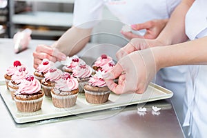 Women in pastry bakery working on muffins