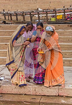 Women performing a Hindu ritual at the Ganges river in Varanasi