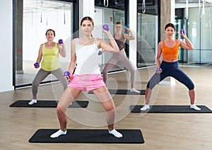 Women performing set of exercises with two small pilates balls
