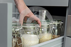 Women picking an item from storage hutch. Smart kitchen organization concept