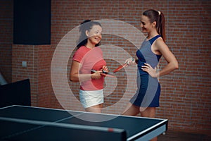 Women play doubles table tennis, ping pong players