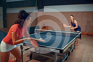 Women play ping pong match, table tennis