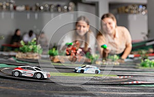 women players playing with slot car racing track