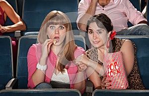 Women With Popcorn Holding Hands