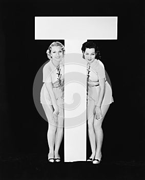 Women posing with huge letter T