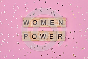 Women power inscription on wooden cubes against color background.