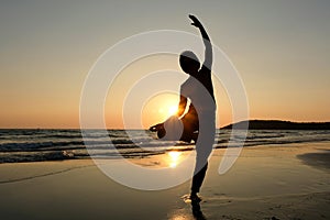 Women practice yoga on the beach of the sea during the morning hours