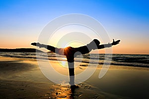 Women practice yoga on the beach of the sea during the morning hours