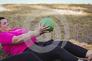 Women practicing ball sit up exercise in the boot camp