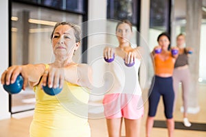 Women practicing pilates with balls at group class in yoga studio