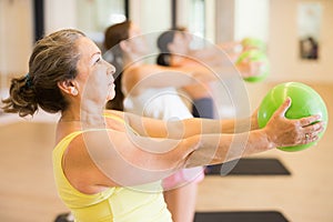 Women practicing pilates with balls at group class in yoga studio