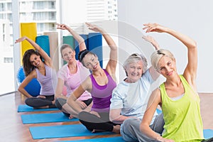 Women practicing stretching exercise in gym class