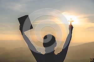 A women is praying to God on the mountain. Praying hands with faith in religion and belief in God on blessing background. Power of