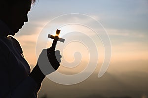 A women is praying to God on the mountain. Praying hands with faith in religion and belief in God on blessing background. Power of