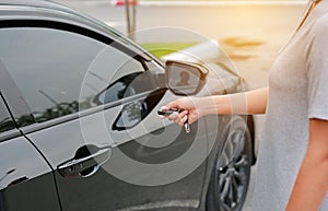 Women pressing the button on the remote to lock or unlock the car