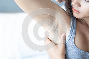 Women problem black armpit lying on white bed background for skin care and beauty concept, selective focus