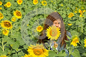 Women is protect her face from sun light in sunflowers field