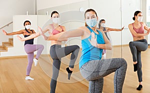 Women in protection fase masks dancing aerobics