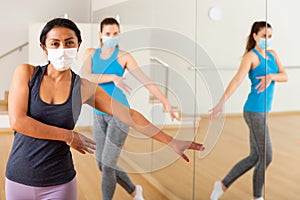 Women in protection fase masks dancing aerobics