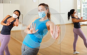 Women in protection fase masks dancing aerobics