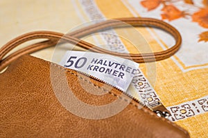 Women purse with a 50 Danish kroner banknote sticking out, Financial concept, Denmark money, home budget, Cash payment in