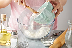 Women puts flour into the glass bowl for cooking tortilla.