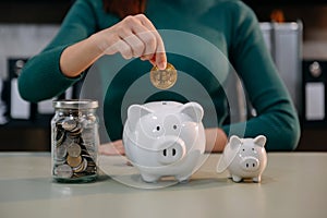 Women are putting coins in a piggy bank for a business that grows for profit and saving money for the future. planning for