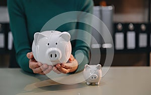 Women are putting coins in a piggy bank for a business that grows for profit and saving money for the future. planning for