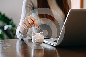 Women are putting coins in a piggy bank for a business that grows for profit and saving money for the future. planning for