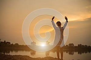 Women raise arms to watch the sunset