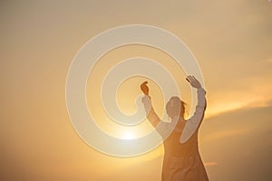 Women raise arms to watch the sunset