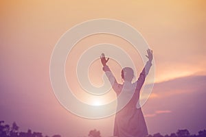 Women raise arms to watch the sunset