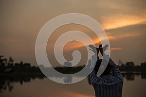 Women raise arms to watch the sunset